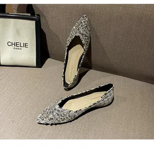 Dettaglio di scarpe basse a punta con strass luminosi e rifiniture in tweed elegante