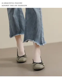 Olivgrüne Ballerinas mit eckiger Zehenpartie, schwarzer Schleife und Denim-Jeans