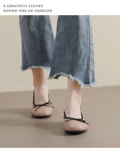 Detailansicht rosa Leder-Ballerinas mit schwarzer Schleife und ausgefranster Jeans