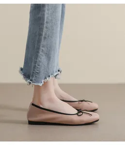 Details von Ballerinas mit quadratischer Zehenpartie, schwarzer Schleife und Lederstruktur