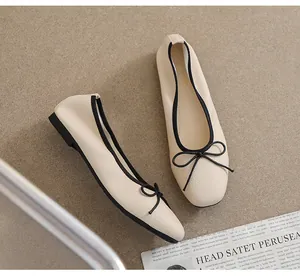 Detailansicht beige Ballerinas mit schwarzer Schleife und strukturierter Lederoptik
