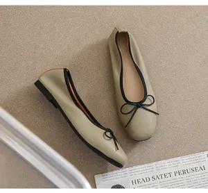 Detailansicht grüner Ballerinas mit quadratischer Spitze, Lederstruktur und Schleife