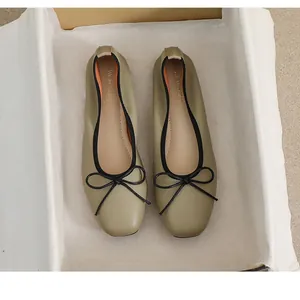 Nahaufnahme der Leder-Ballerinas mit Litschi-Struktur, Schleife und schwarzer Einfassung