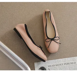 Nahaufnahme der Ballerinas mit eckiger Kappe aus nudefarbenem Leder und schwarzer Schleife