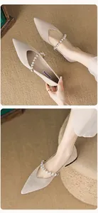 Close-up of beige pointed toe flats with pearl strap and comfortable soft footbed