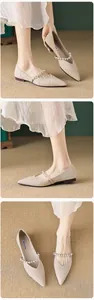 Macro detail of almond pointed-toe flat shoe with elegant pearl strap and fabric texture