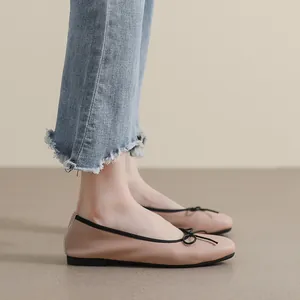 Elegante beige Ballerinas aus Leder mit eckiger Spitze und schwarzer Schleife