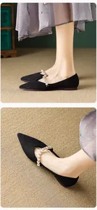 Detail of pointed-toe flats with woven texture and elegant pearl strap decoration