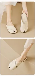 Λεπτομέρεια macro από κρεμ flat mules με χιαστί λουράκια και υφή από δέρμα με κόκκους