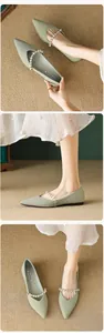 Detail of light green pointed-toe flat shoe featuring elegant pearl bead strap and texture