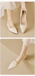 Detail von spitzen Mary Jane Flats mit gewebter Kette und Perlen auf beigem Leder