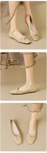 Close-up of elegant beige square toe ballet flats with knotted pleat detail and soft sole