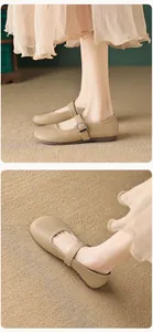 Detailed close-up of beige Mary Jane flats with round toe and silver metal buckle
