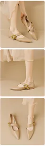 Detailed views of beige pointed-toe flats with decorative large golden horse-bit buckle