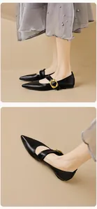 Detail of black pointed toe Mary Jane flats with gold buckle and adjustable strap