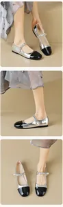 Detail of silver Mary Jane flat shoes with black patent toe and pearl chain strap
