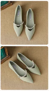Macro view of light green pointed-toe flat shoe with pearl accent and fabric texture