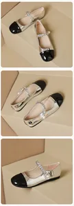 Macro shot of silver Mary Jane flats featuring pearl chain detail and black patent toe