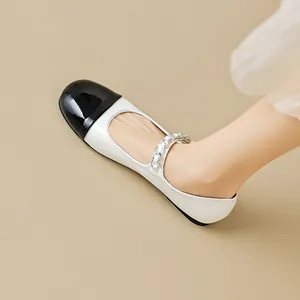 Elegant two-tone Mary Jane flats in black and white with a metallic chain strap