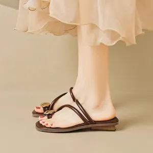 Sandales plates à entre-doigt marron foncé avec boucle dorée et semelle boisée pour femme