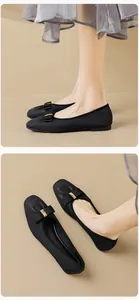 Detailansicht schwarzer Ballerinas mit Bandschleife und goldener Metallschnalle