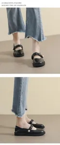 Detalle de zapatos Mary Jane negros con plataforma, correa trenzada y gran perla blanca