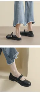 Detalle de zapatos Mary Jane negros con plataforma, hebilla de perla y vaqueros rotos