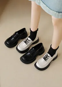 Detail view of lace-up platform loafers in black and beige for a retro college style