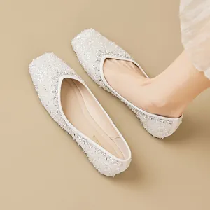 Elegant white square toe flat shoes with glittering rhinestones and sequins on feet