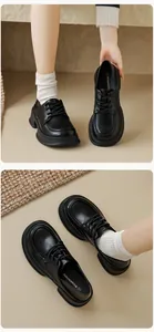 Detailed close-up of matte black platform loafers featuring lace-up closure and soft soles