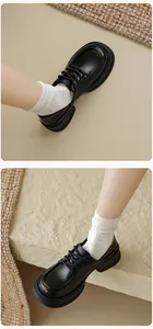 Close-up of black platform loafers with lace-up design and thick anti-slip soles