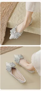 Detailopname van puntige platte schoenen met een fonkelende strass-strik voor dames