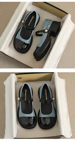 Detail van blauwe denim Mary Janes met zwarte lakschoenneus en parelvormige gesp