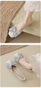 Detailweergave van zilveren glitter flats met sprankelende strass-strik versieringen