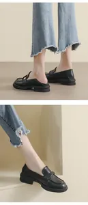 Dettaglio mocassini neri platform con moneta d'oro e design del tallone convertibile