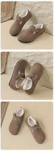 Détail des mules en daim marron avec doublure en fausse fourrure blanche et boucle métal