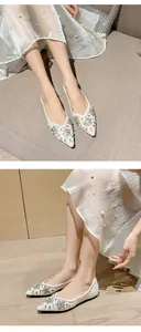 Macro view of white pointed-toe flats with sparkling rhinestones, sequins and pearls