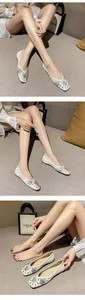 Detail of white pointed-toe flats featuring sparkling sequins and rhinestone embellishments