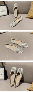 Detailed view of white ballet flats with sparkling crystals and pearl snowflake patterns