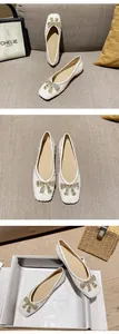 Dettaglio di scarpe basse bianche con paillettes e fiocco di strass in stile lussuoso