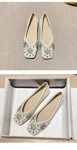 Close-up of elegant pointed-toe flat shoes featuring shimmering rhinestones and sequins
