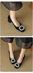 Detail of black suede block heel pumps with elegant sparkling rhinestone buckle ornament