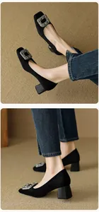 Detailed view of black suede square toe pumps with elegant rhinestone buckles and chunky heels