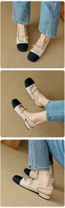 Detail of beige slingback Mary Janes with black toe cap and elegant pearl strap