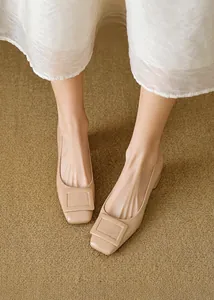 Dettaglio delle décolleté minimaliste in pelle verniciata beige con punta squadrata e fibbia