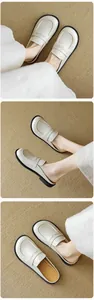 Detailed top and side view of beige leather closed-toe mules with wavy stitching details