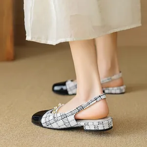 Classic black and white tweed slingback flats with pearl accents and patent leather cap toe