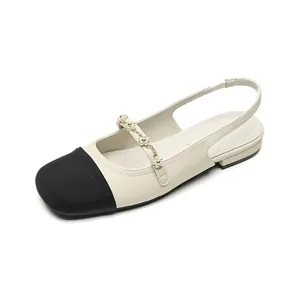 Classic two-tone slingback flats with black toe and pearl embellished strap detail