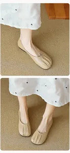 Detail shot of beige round toe ballet flats with pleated soft leather texture