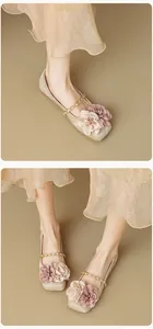 Detail of square toe flat shoe with champagne gold fabric and floral chain strap